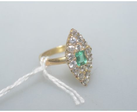 An emerald and diamond dress ring in a marquise setting, the central emerald cut emerald approx. 0.35cts, total diamond weigh