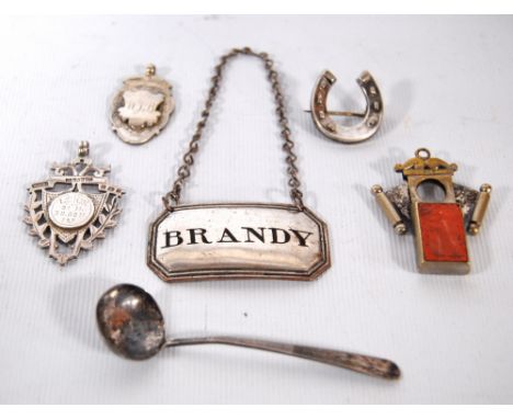 Miniature silver ladle, Birmingham 1804, two silver medallions, a similar scarf pin, an Old Sheffield decanter label, 'Brandy