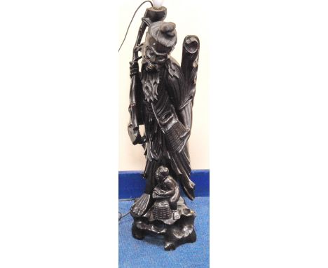 20th century oriental carved hardwood table lamp base in the form of a deity with carp and basket and a child at foot, 72.5cm