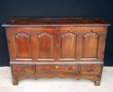 George III oak blanket chest, the moulded rectangular top over panelled doors, short drawers and shaped apron raised on brack