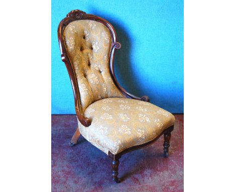 Victorian mahogany framed lady's button-back chair with floral carved pediment, serpentine seat and raised on tapering balust