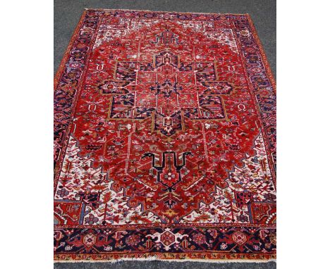 Persian carpet with central floral medallion over red ground, spandrels and all over floral decoration and border, 340cm x 25