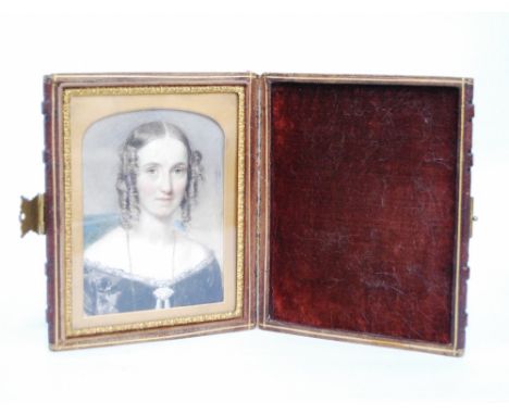 Early 19th century miniature portrait of a lady, watercolour on paper, 10.5cm x 8cm, in folding leather frame.