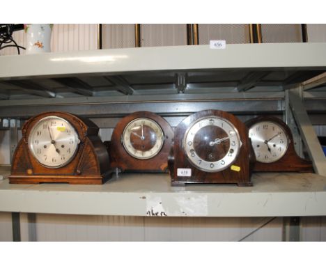 A walnut and inlaid three hole mantel clock and three other mantel clocks