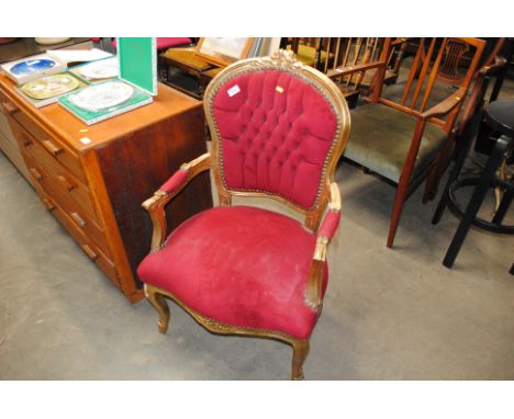 A button back upholstered and gilt armchair