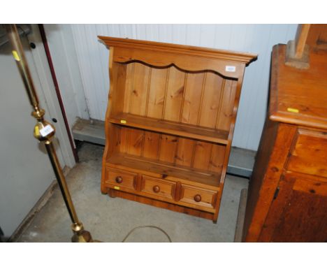 A pine wall shelf fitted three drawers