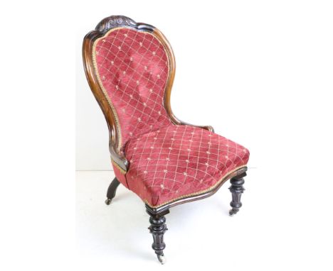 Victorian Walnut Balloon Button Back Salon Chair with red and gold upholstery raised on carved turned front legs with castors