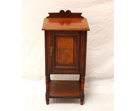 EDWARDIAN ROSEWOOD POT CUPBOARDwith a shaped raised back above a panelled door, standing on ring turned tapering supports uni