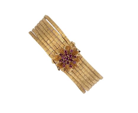 A ruby set bracelet, seven rows with a textured finish, decorative floral clasp set with round faceted rubies, two figure of 