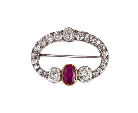 A Burmese ruby and diamond brooch, rubover set oval faceted ruby, flanked by two old mine cut diamonds, one approximately 6.5