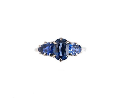 A three stone Burmese sapphire ring, central claw set oval faceted sapphire, flanked by two pear shaped sapphires, size N, un