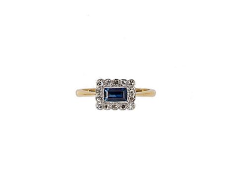 A sapphire and diamond panel ring, rectangular panel with a central rectangular step cut sapphire, estimated approximate weig