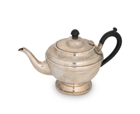 A George V silver teapot, mark of Aaron Lufkin Dennison, Birmingham 1932, of circular form with part marked hinged cover, bla