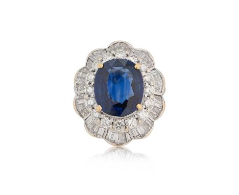 A modern sapphire and diamond cluster ring, claw set oval faceted sapphire, approximately 12.5 x 10.5 x 5mm, estimated approx