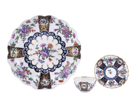 A WORCESTER POLYCHROME LOBED DISHCIRCA 1770Painted with panels of flowers, blue fret square mark, 25.5cm diameter;and a tea b