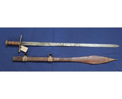 An ethnic sword with leather tooled scabbard
