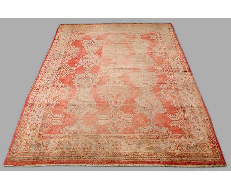 A TURKISH USHAK CARPET in tones of red, green and blue (faded and worn) 13' 2" (403cm) x 11' 1" (339cm)