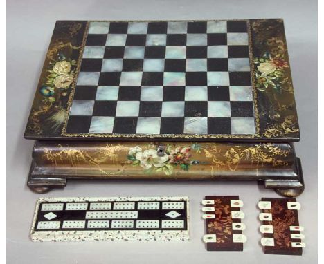 A VICTORIAN PAPIER MACHE GAMES BOX inlaid with mother of pearl and with hand painted floral decoration.  The interior with cr