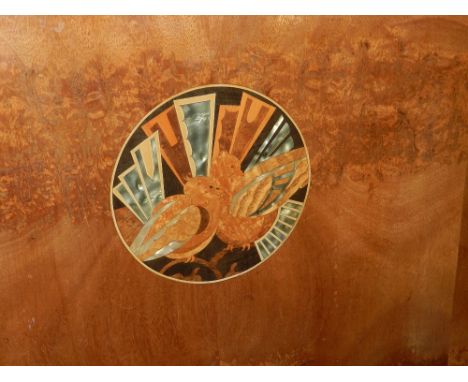 A French Art Deco walnut bedstead of concave form, inlaid with a specimen wood and mother of pearl marquetry panel, decorated