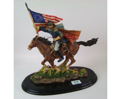 A ceramic figure of a cowboy riding a horse: on wooden plinth 