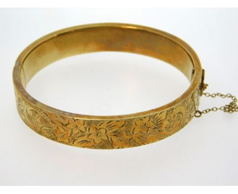 A 9ct gold bangle with chased decor, internal measurement 60mm, 16.8g