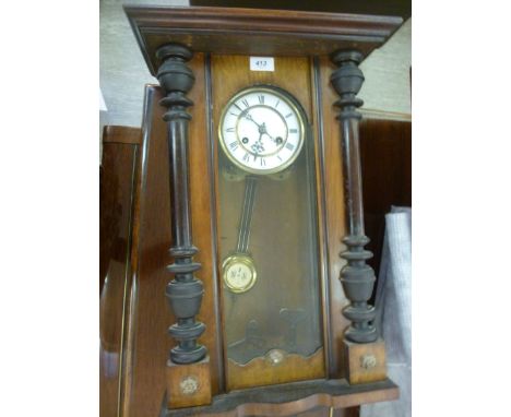 An early 20thC walnut cased Vienna clock with traditionally turned and carved ornament; the gong strike movement faced by a w
