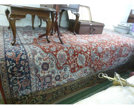 A Persian design machine made carpet with a central medallion on a red ground  79'' x 68''       BSR