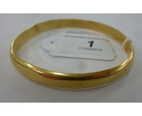 A yellow metal bangle bears impressed Arabic text decoration      11