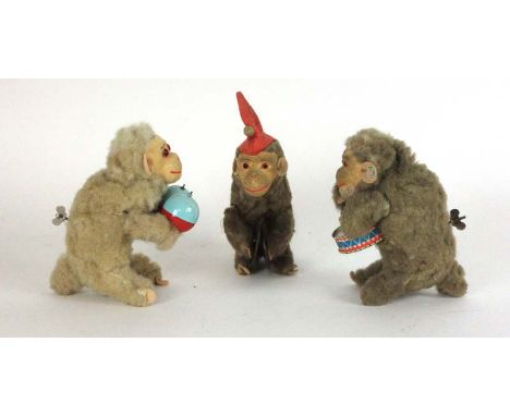 A set of three West German clockwork monkeys with cymbals, drum and maracas  