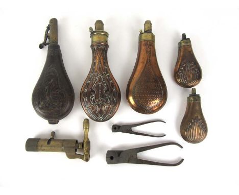 A selection of 19th century shooting accessories to include embossed powder flasks, leather shot flask, bullet molds, shot lo