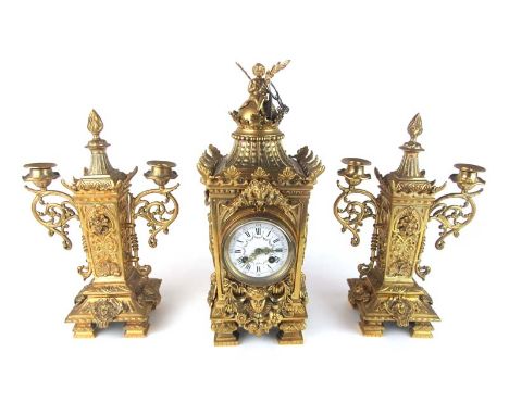 A 19th century French gilt brass clock garniture richly embellished with cherub and flame finial's, lion and face masks and f