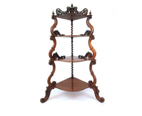 A Victorian walnut four tier corner what-not, with pierced gallery over serpentine shelves and carved S-scroll supports, h. 1