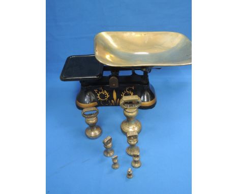 A set of kitchen weighing scales, with brass butchers weights
