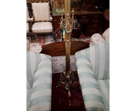 AN ATTRACTIVE BRASS STANDARD LAMP, with three light fittings on an ornate reeded stem, applied with leaf swags and urns, on a