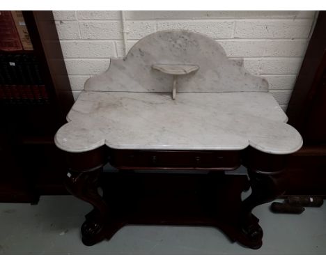 A VICTORIAN MAHOGANY WASHSTAND, the arched marble back with a bracket shelf and shaped marble top above a frieze drawer, rais