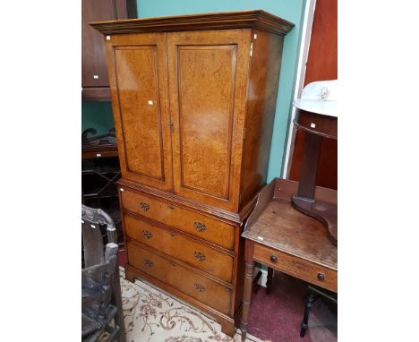 A GOOD QUALITY GEORGIAN STYLE ELM AND BIRDS EYE MAPLE CUPBOARD ON CHEST, O.R.M., the moulded cornice above two panel doors, e