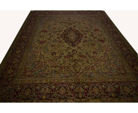 A PERSIAN KERMAN LAVAR CARPET, with centre oval medallion, on a light green ground, with all over floral pattern and conformi