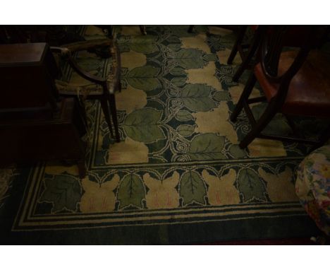 A GOOD HEAVY WOOL RUG, in the William Morris style, with rows of leaf sprays, in light green and ivory, inside a conforming l