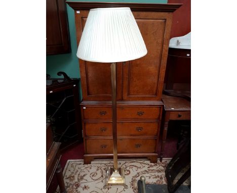 A MODERN BRASS CORINTHIAN STYLE STANDARD LAMP, with reeded stem and stepped base, with brass lion paw feet; and another simil