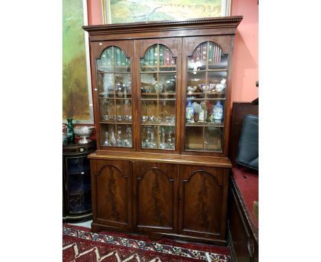 AN ATTRACTIVE VICTORIAN BOOKCASE, the upper section with a dentil-moulded cornice, above three arched and glazed doors, each 