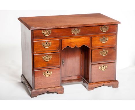 A GEORGE III PERIOD MAHOGANY KNEE-HOLE DESK, the rectangular moulded hinged top opening to reveal a fitted interior, with var