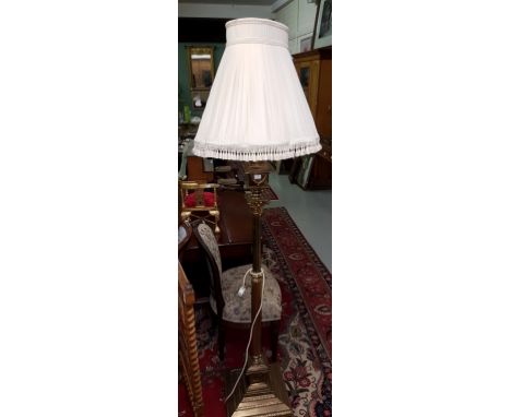 A BRASS CORINTHIAN STYLE STANDARD LAMP, on square stepped base, and pleated cream shade. (1) 