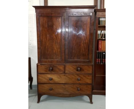 A REGENCY PERIOD MAHOGANY GENTLEMAN'S LINEN CUPBOARD, the moulded cornice above two bead-moulded paneled doors on a chest bas