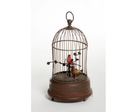 AN OLD BRASS BIRDCAGE AUTOMATON, with singing bird, perched in a cage with dome top, 12" (30cm). (1) 