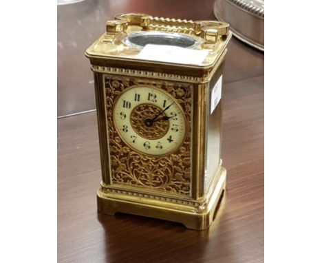 AN ATTRACTIVE FRENCH BRASS FIVE GLASS CARRIAGE CLOCK, in the Gothic style, with swing handle and openwork bands, the corners 