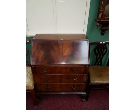 A CHIPPENDALE STYLE MAHOGANY SLOPE-FRONT BUREAU, with fitted interior and three drawers, raised on cabriole legs with ball n 
