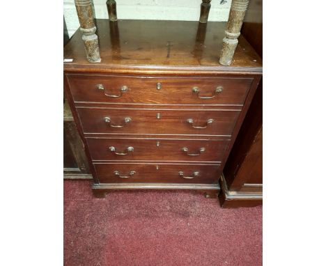 A GEORGIAN MAHOGANY NIGHT-TIME COMMODE, in the form of a chest with four mock drawers, the top lifting to reveal a seat, unfu