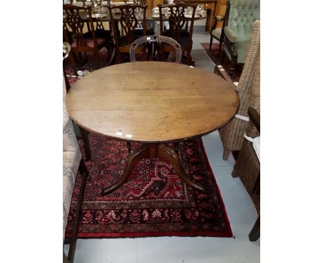 A GEORGIAN CIRCULAR FLIP TOP OAK CENTRE TABLE, on baluster turned stem and tripod base, 38” (96cm)d. (1) 