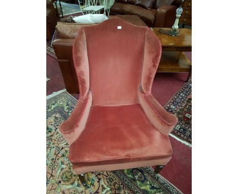 A MAHOGANY WING BACK ARMCHAIR, with outward curved elbow rests, cushion seat raised on front square tapering legs. (1)