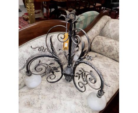 A THREE BRANCH WROUGHT IRON CEILING LIGHT, in the form of scrolling foliage, the arms supporting three milk glass bulbous sha
